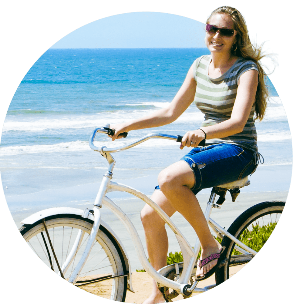 Woman biking on beach trail