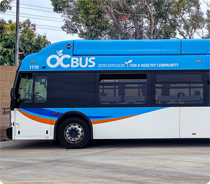 An OC Bus, written on the side states "Zero Emission for a Healthy Community"